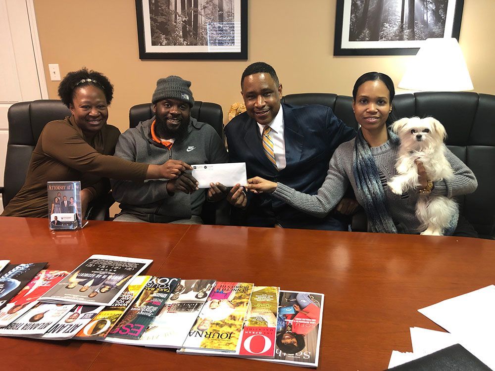A group of people are sitting around a table with magazines and a dog