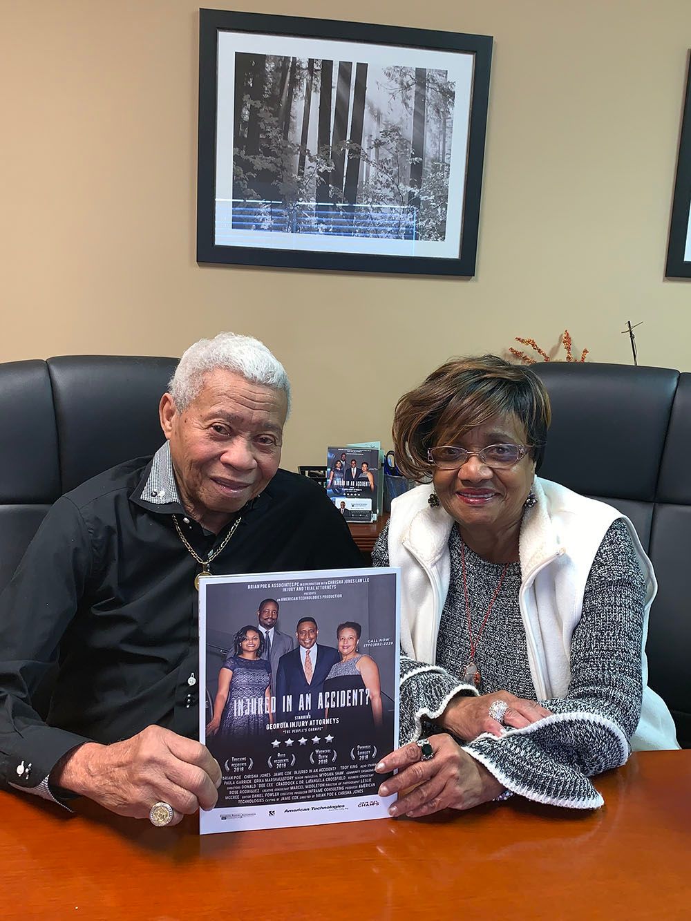 A man and a woman are sitting at a table holding a flyer