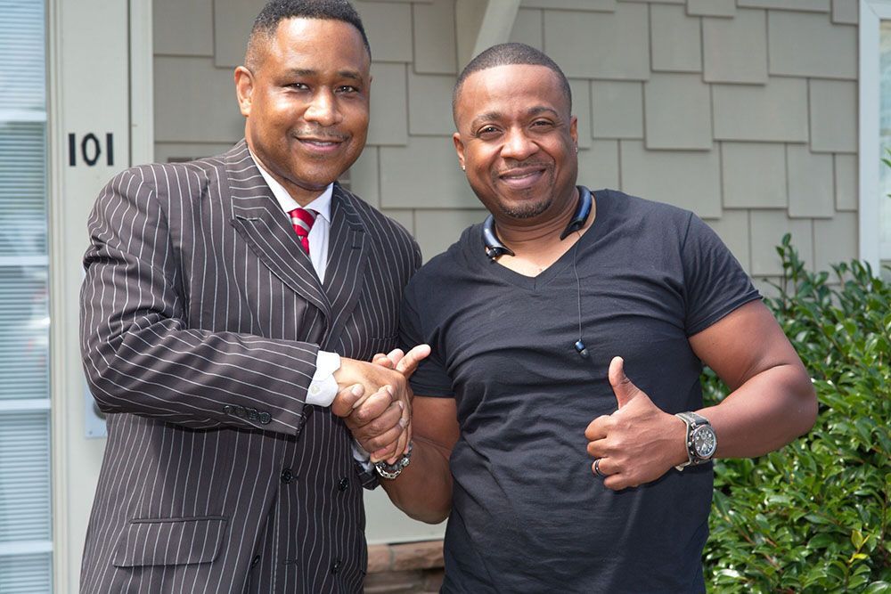 Two men shaking hands in front of a building
