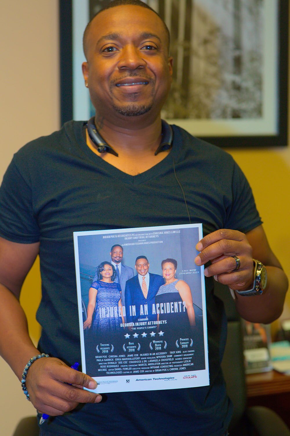 A man in a black shirt is holding a flyer