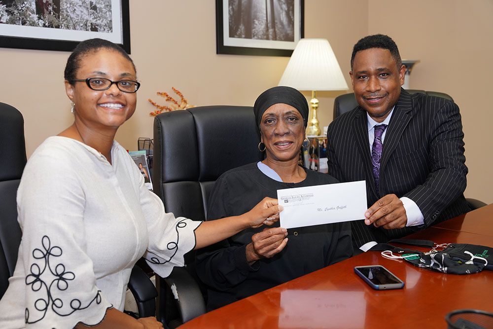 Georgia Injury Attorneys handing a check to a happy client