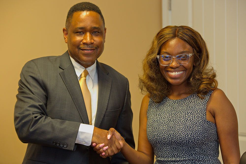 Brian D. Poe, Esq. is shaking hands with a client