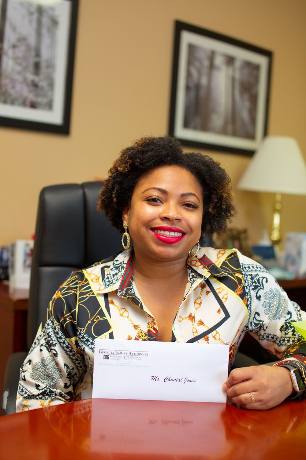 A joyful client is sitting at a desk holding a check