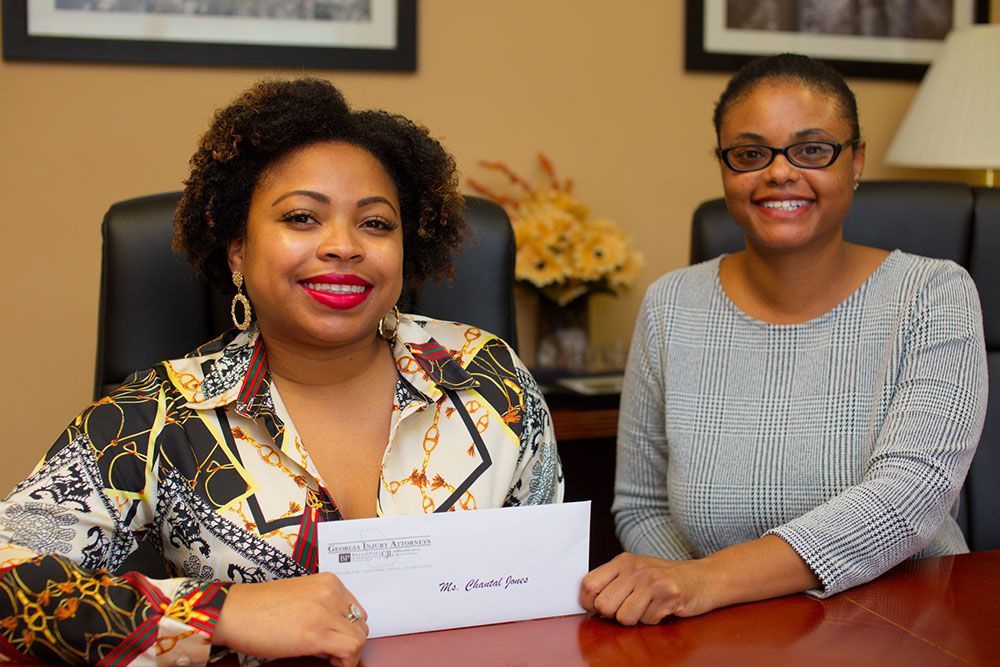 Jamie S. Cox, Esq. handing a check to a happy client