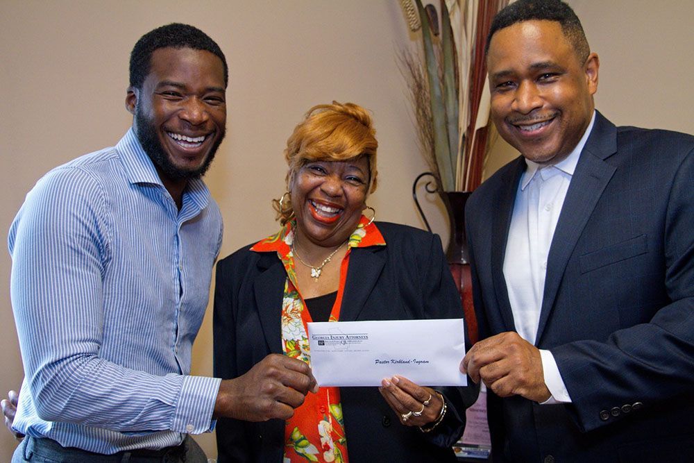 Georgia Injury Attorneys handing a check to a woman