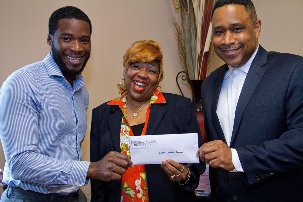 A woman is sitting at a desk holding an envelope