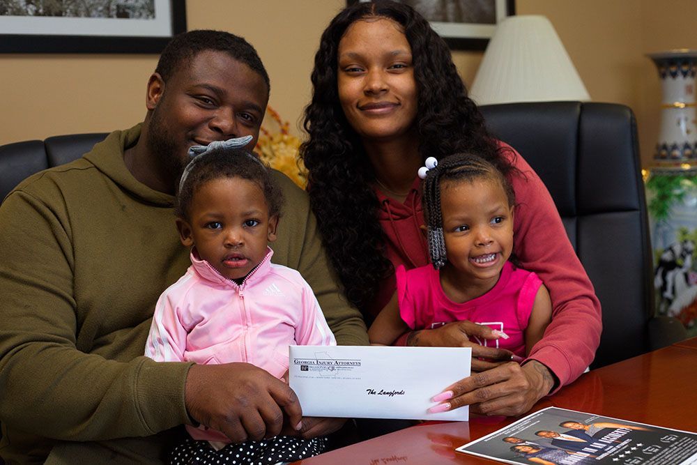 A happy family is sitting at a table holding a check