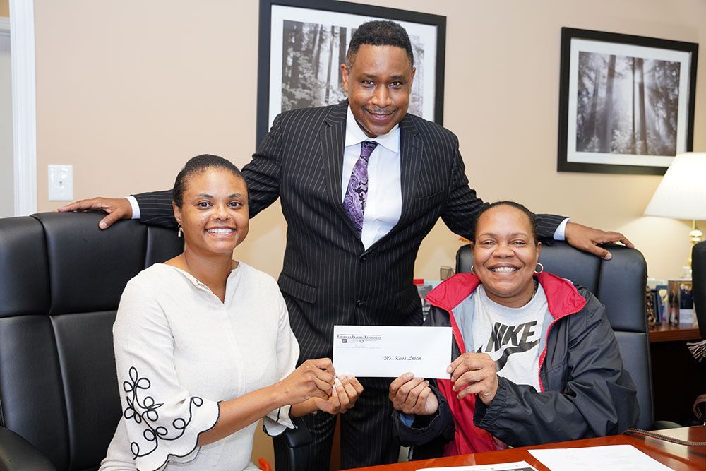 Georgia Injury Attorneys giving an envelope to a happy client