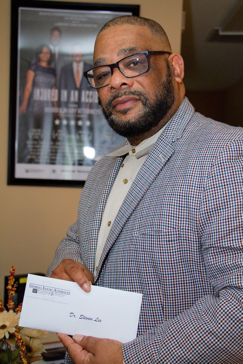 A happy client in a suit and glasses is holding a check in his hand