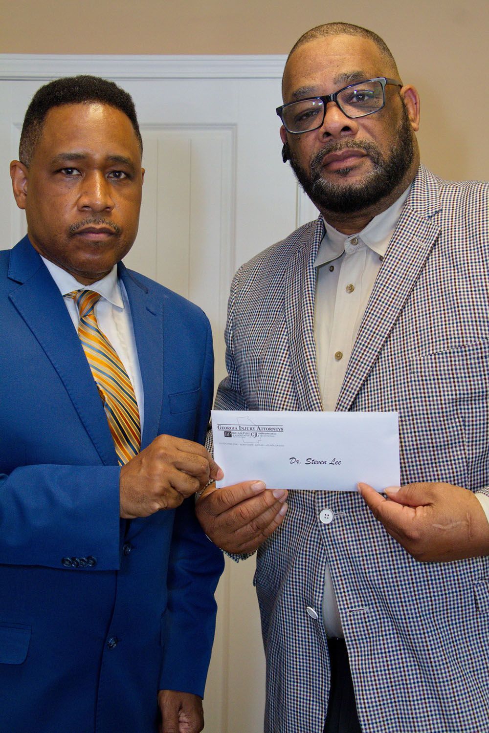 Brian D. Poe, Esq. handing a check to a client
