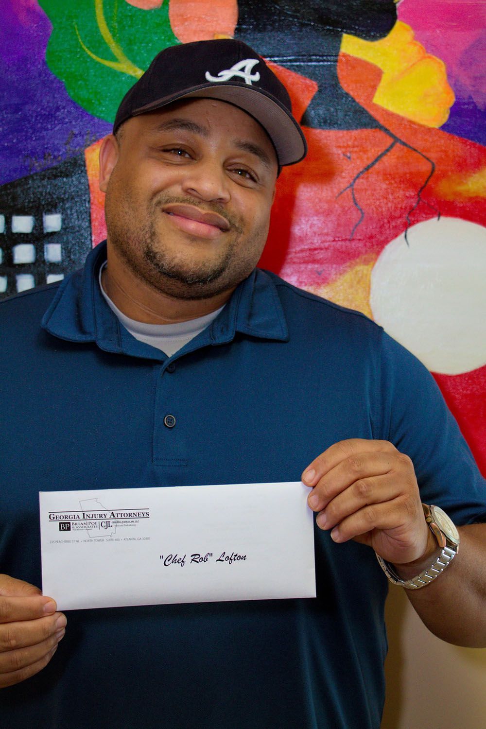 A man in a hat is holding an envelope