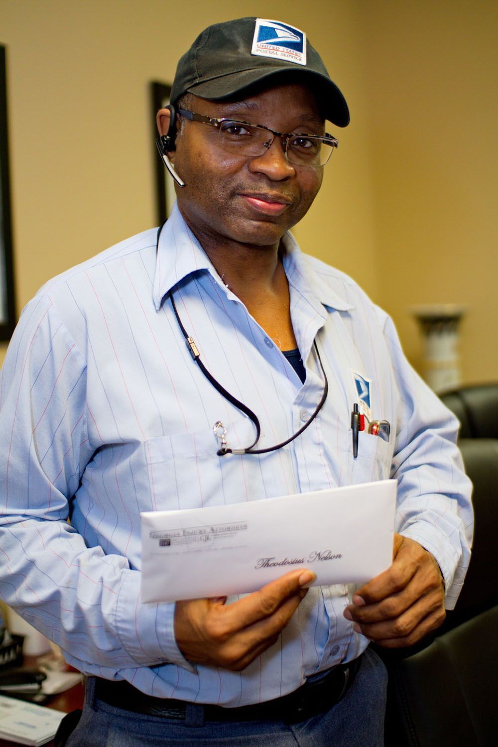 A client wearing a hat is holding a check