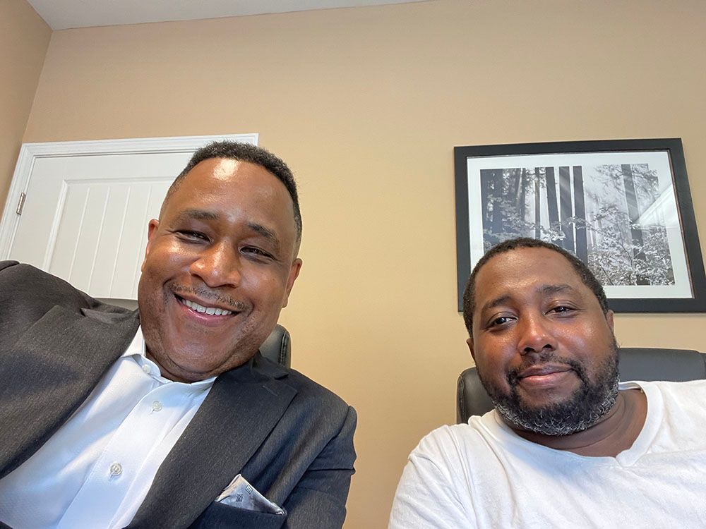 Brian D. Poe, Esq. and a happy client wearing white shirt