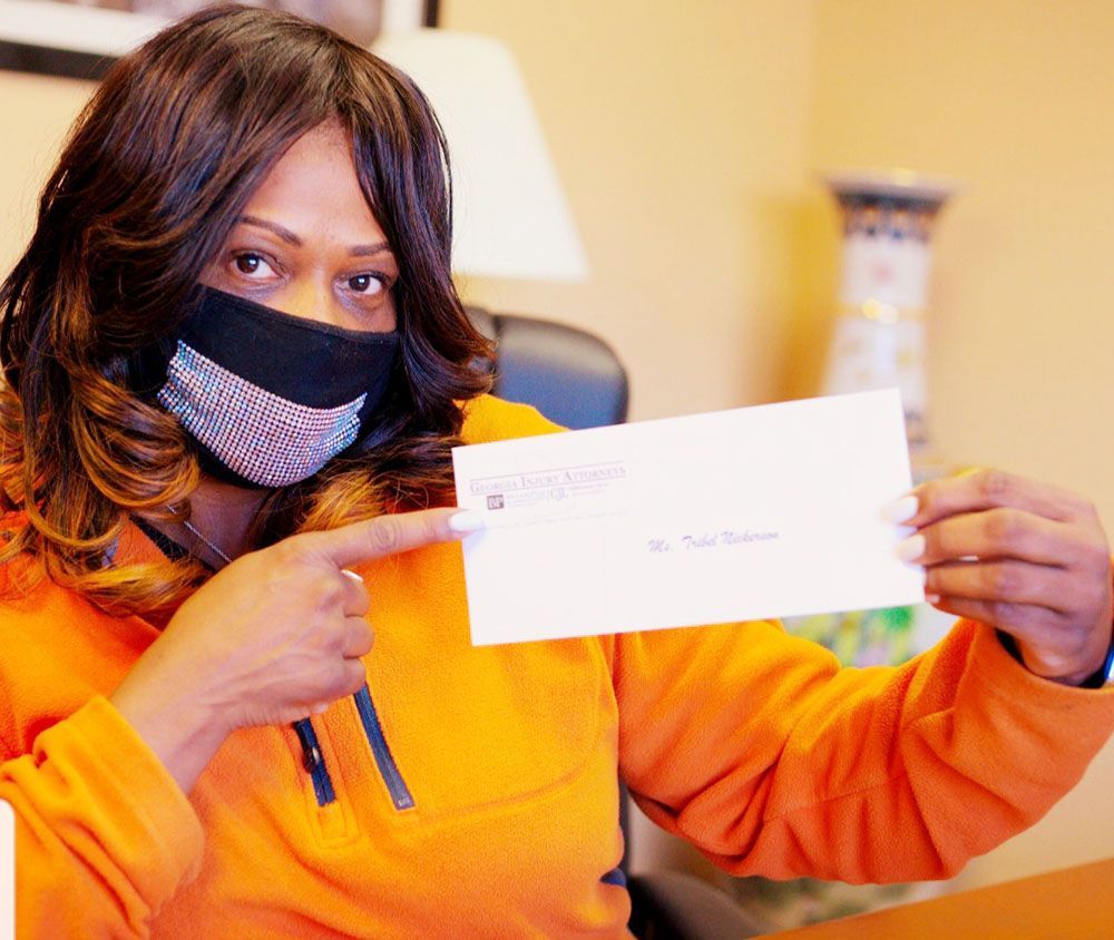 A woman wearing a mask is pointing at a check