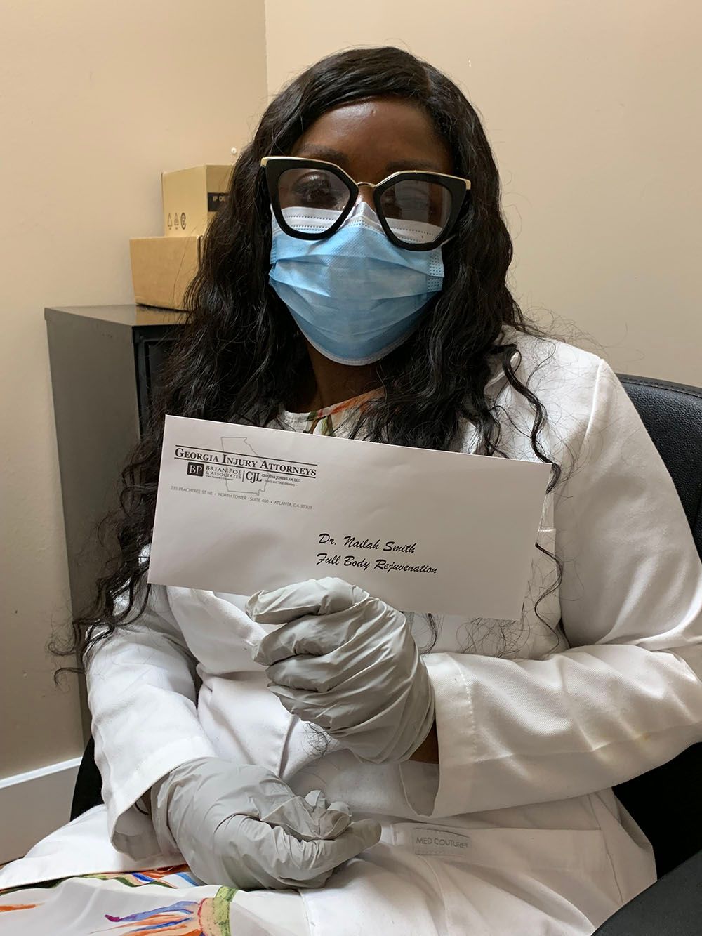 A woman wearing a mask and gloves holding a check