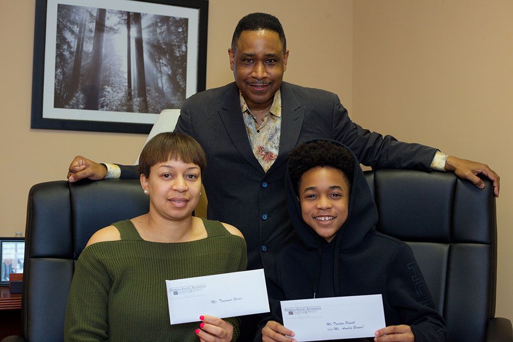 Brian D. Poe, Esq. and his happy clients holding their checks