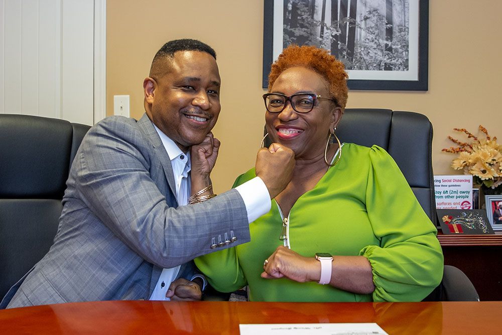 Brian D. Poe, Esq. and a happy client in a green dress