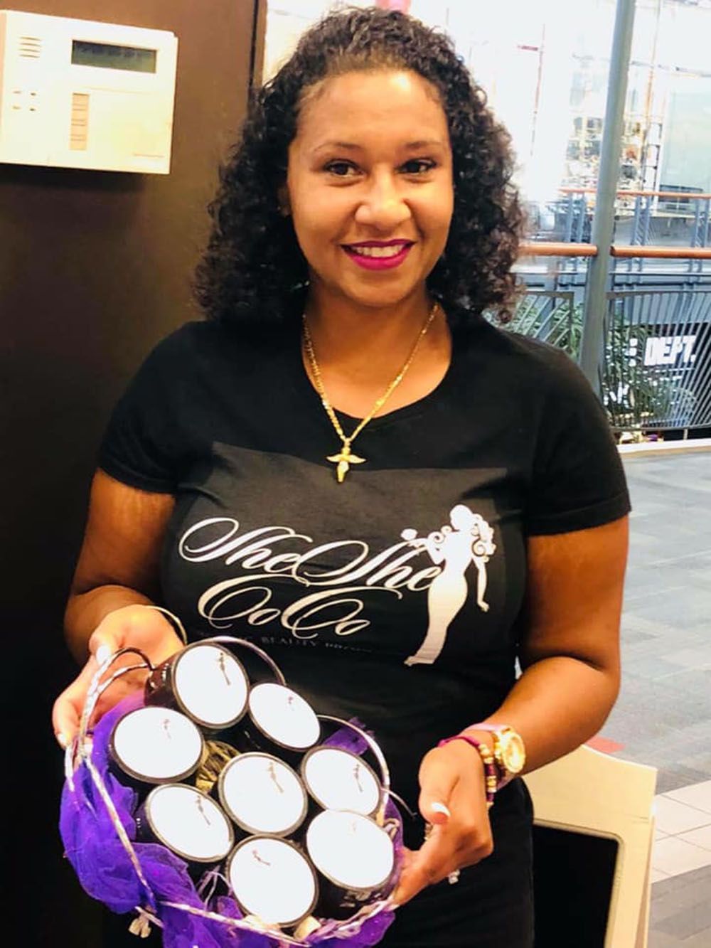A woman in a black shirt is holding a basket of candles