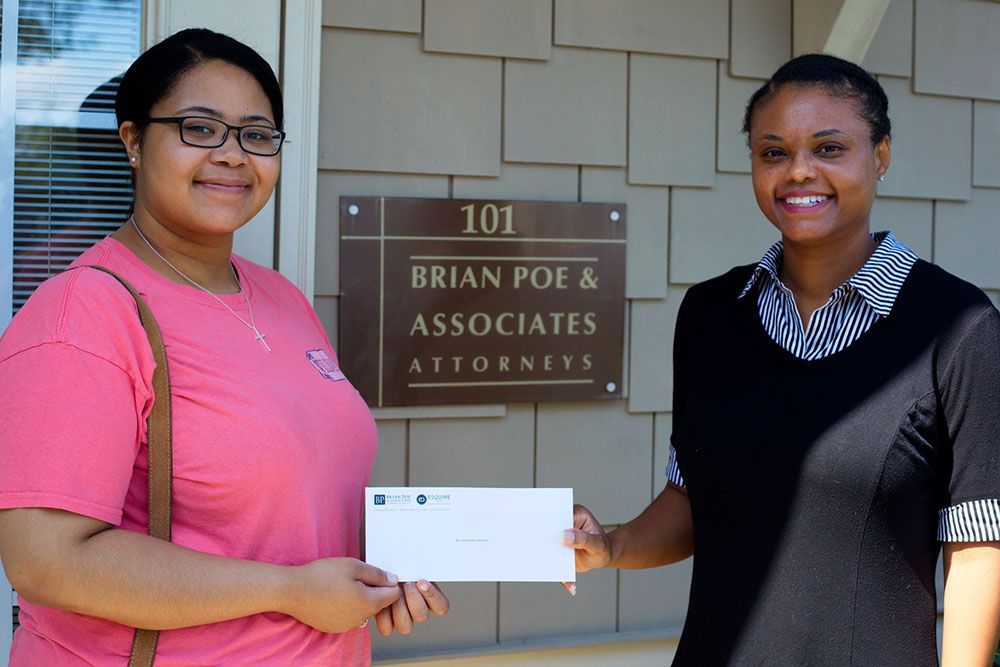 Jamie S. Cox, Esq. giving a check to a client