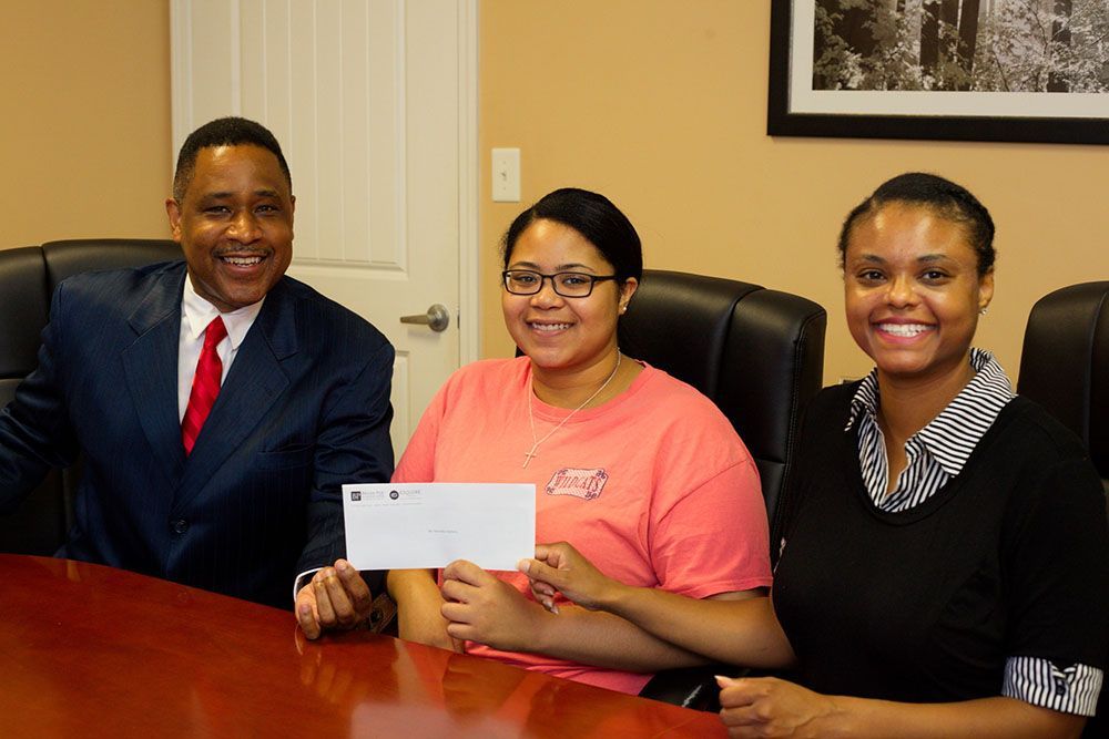 Georgia Injury Attorneys with a happy client holding a check