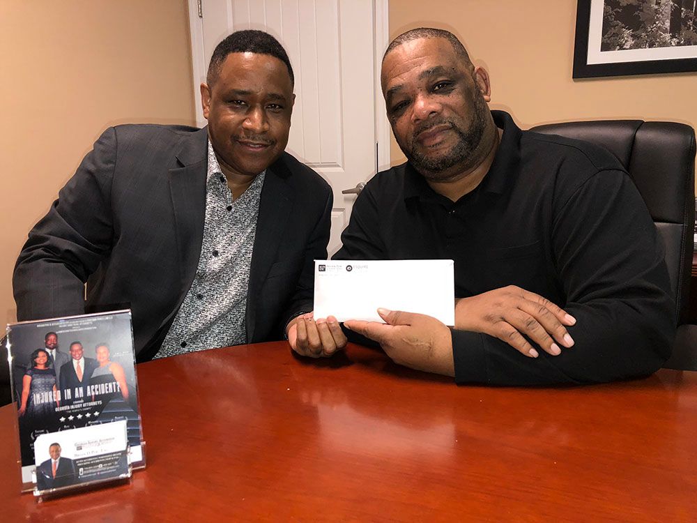 Two happy men are sitting at a table holding a check