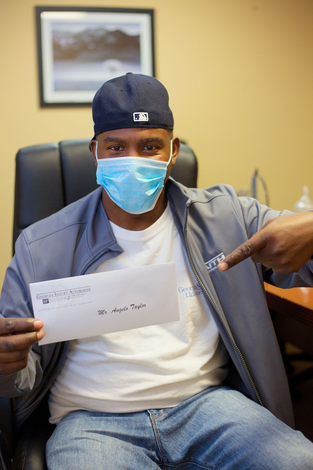 A man wearing a mask is pointing at a check