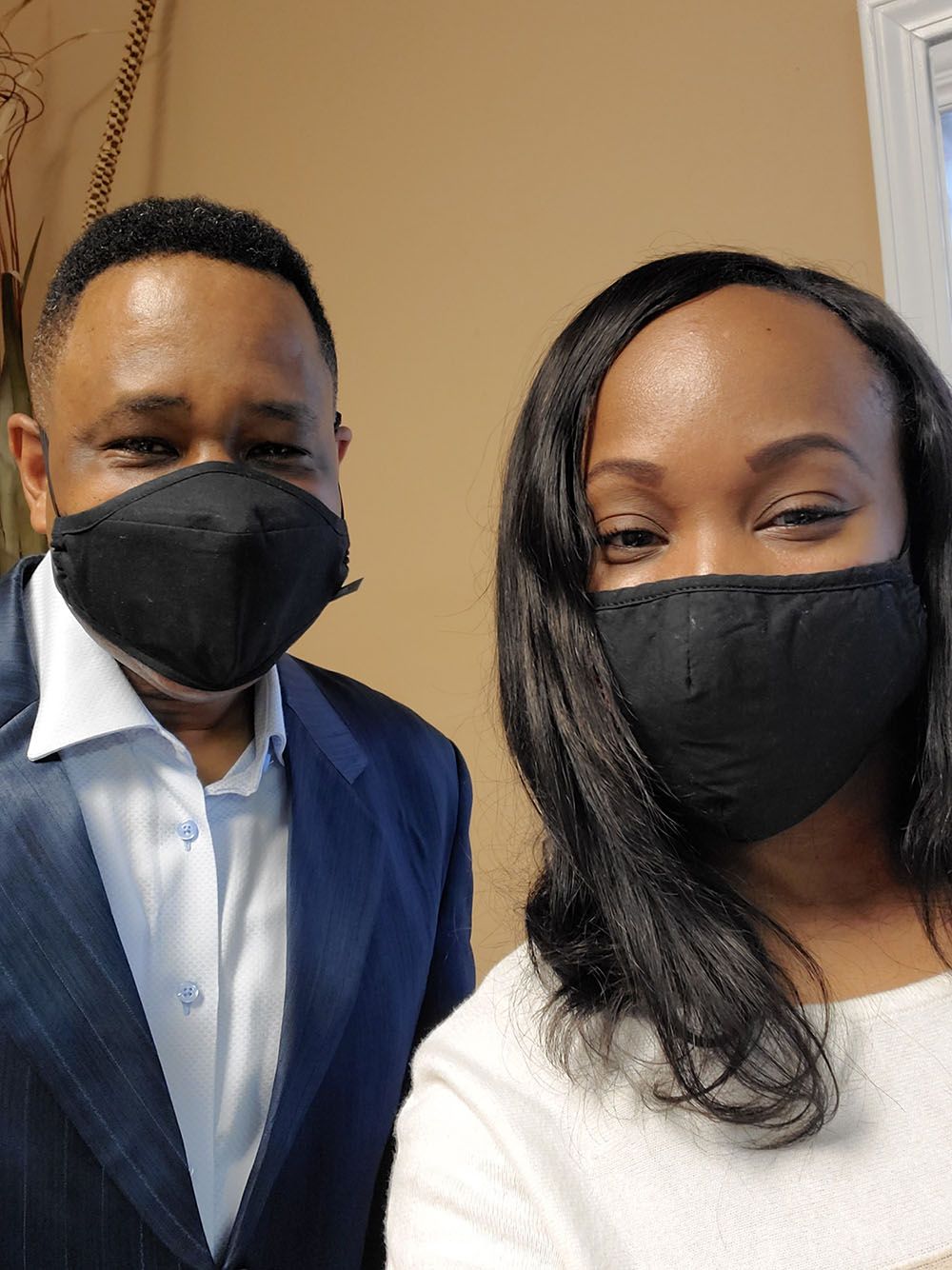 A man and a woman wearing face masks are standing next to each other