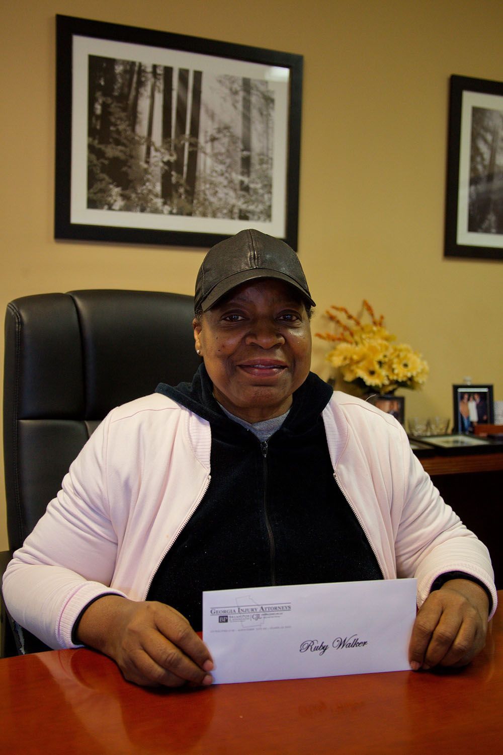 A woman is sitting at a desk holding a check