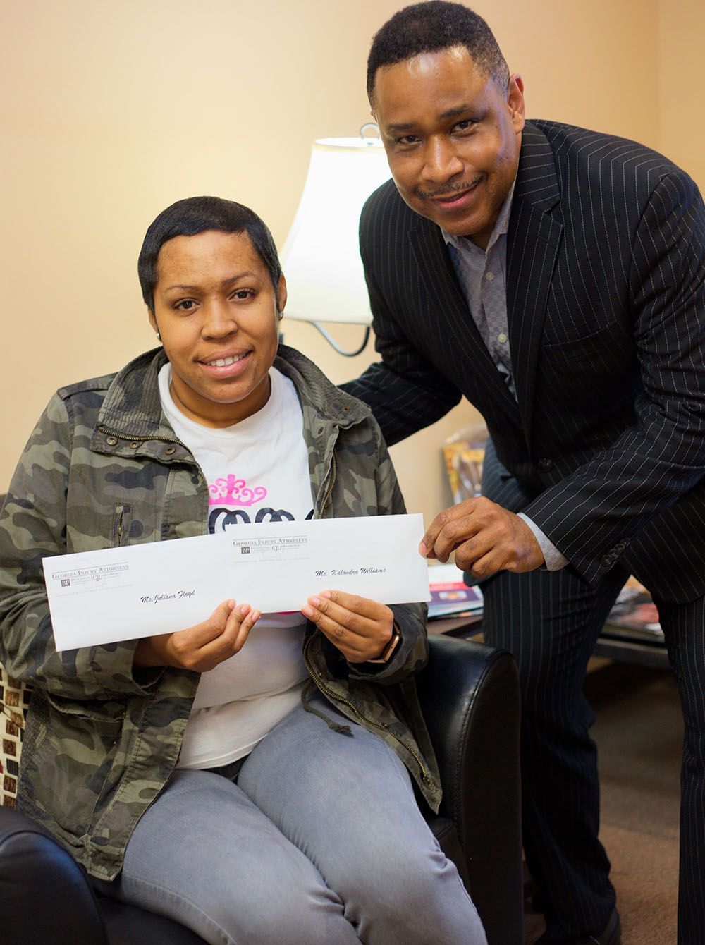 Brian D. Poe, Esq. is giving a woman 2 checks