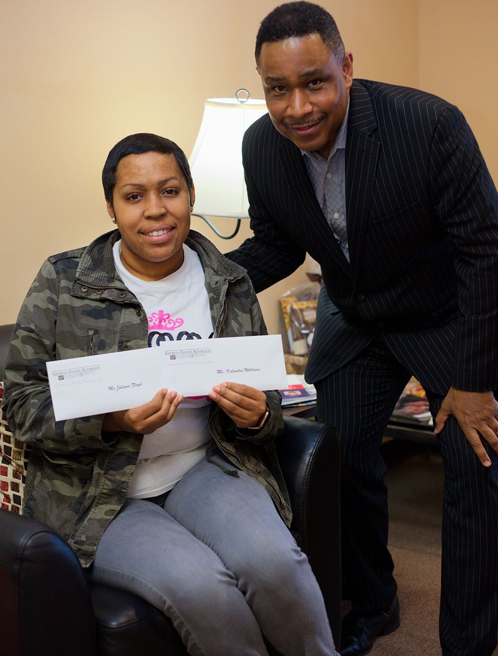 A happy client holding 2 checks