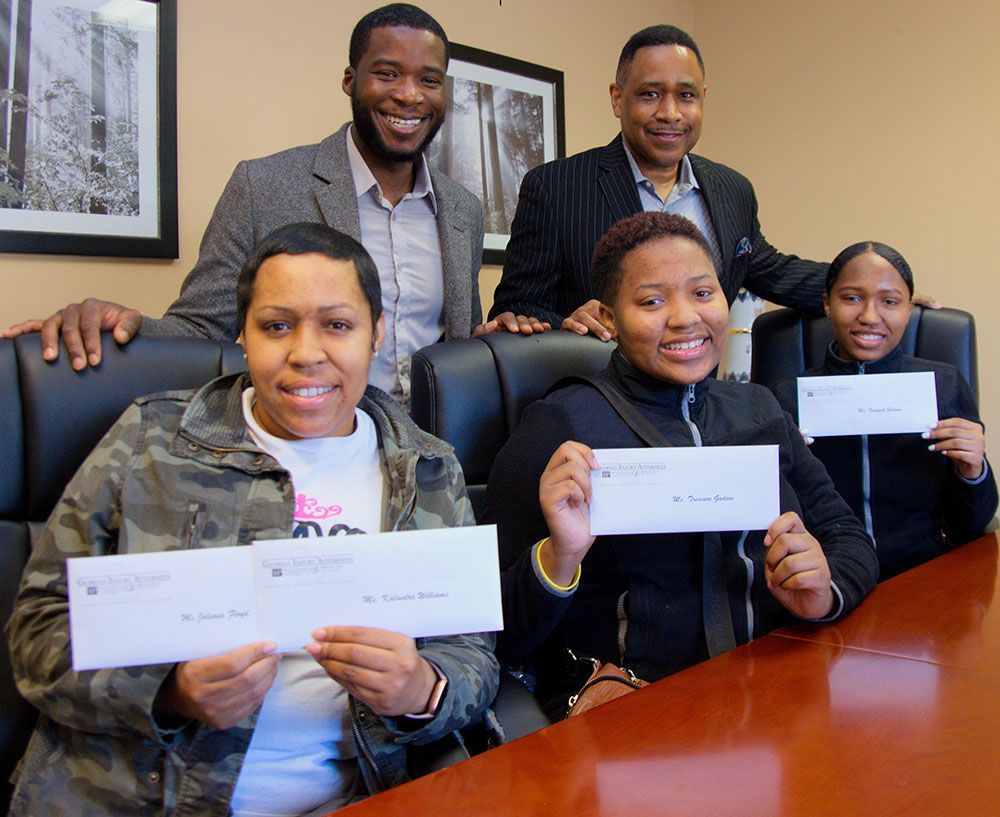 Georgia Injury Attorneys happy clients showing their checks