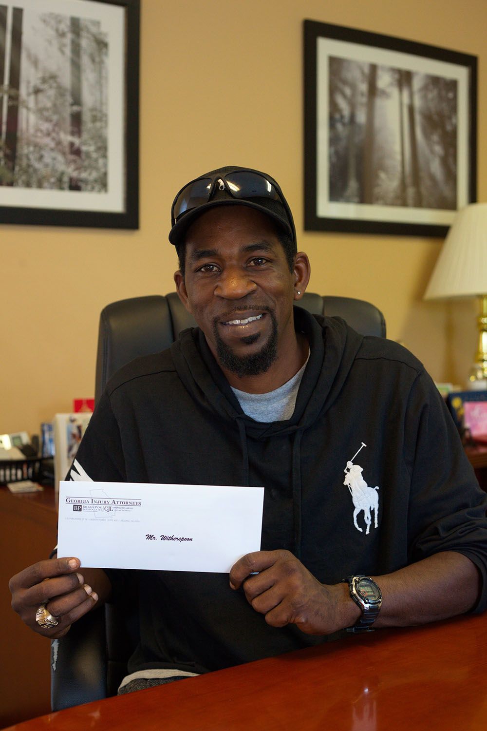 Georgia Injury Attorneys happy client holding a check