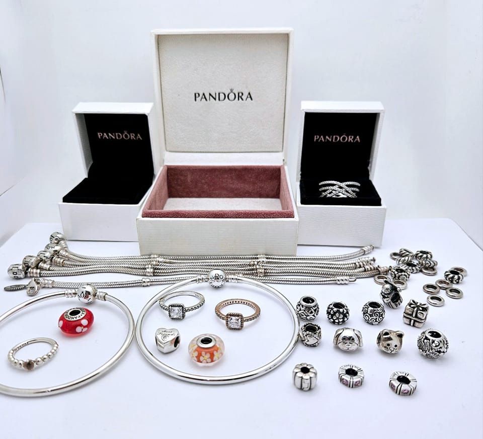 A display of pandora jewelry including bracelets rings and beads