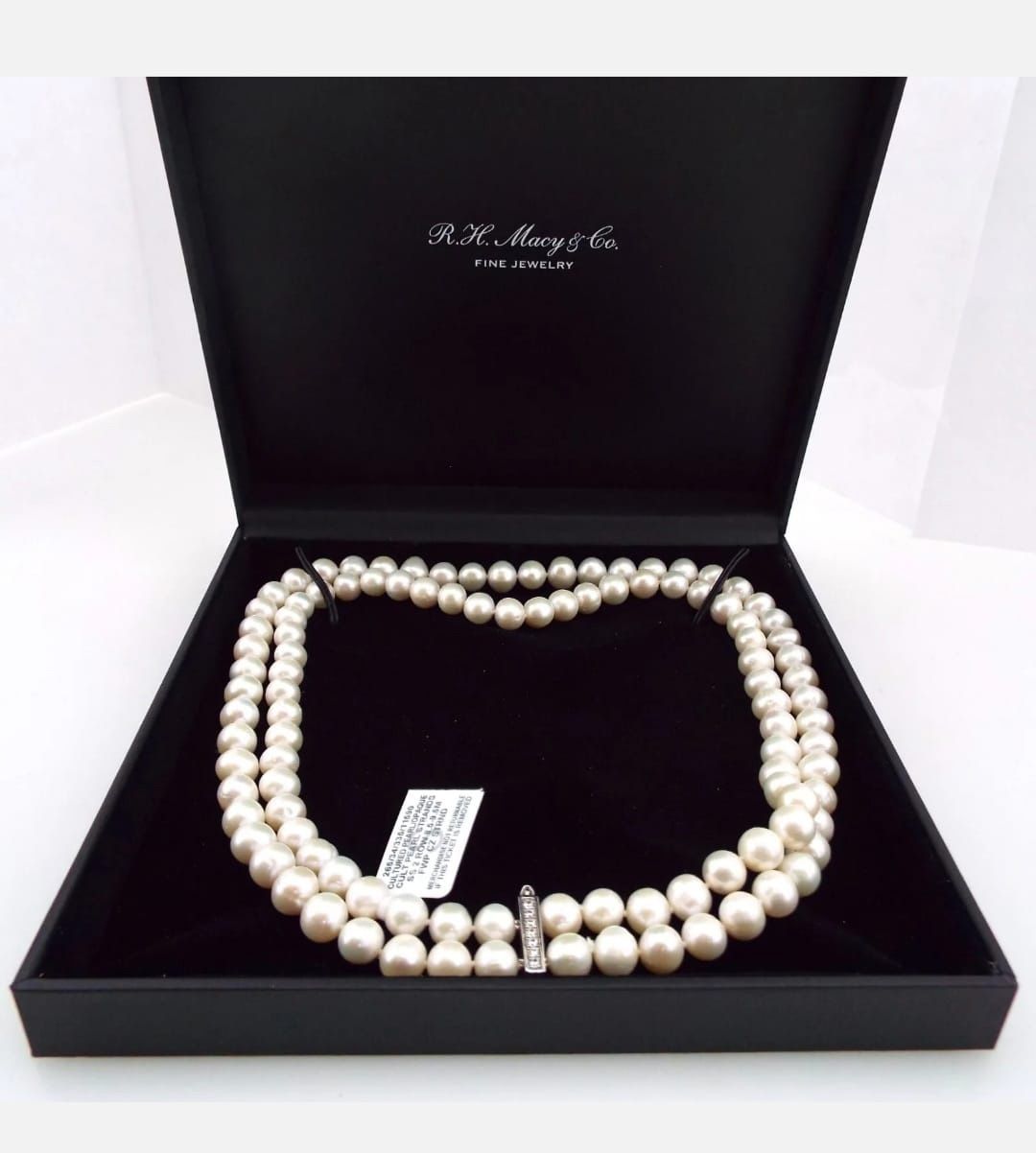 A pearl necklace is in a black box