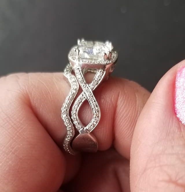 A woman is holding a diamond ring on her finger