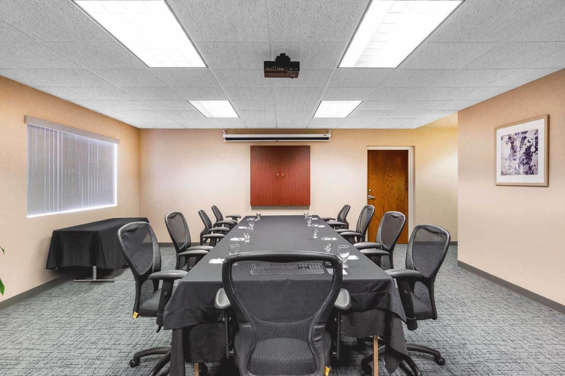 A conference room with a long table and chairs.