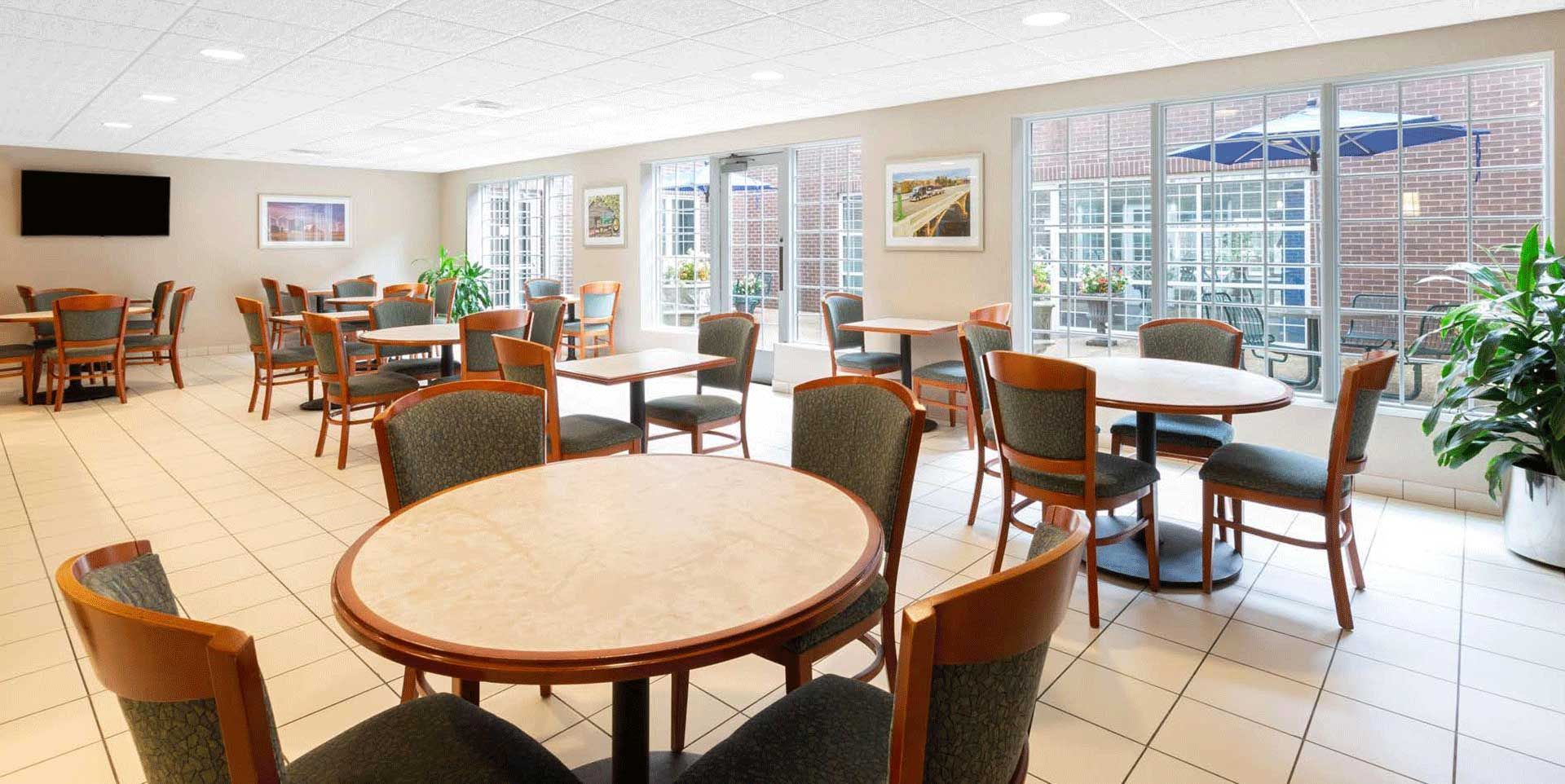 A large dining room with tables and chairs and a flat screen tv.