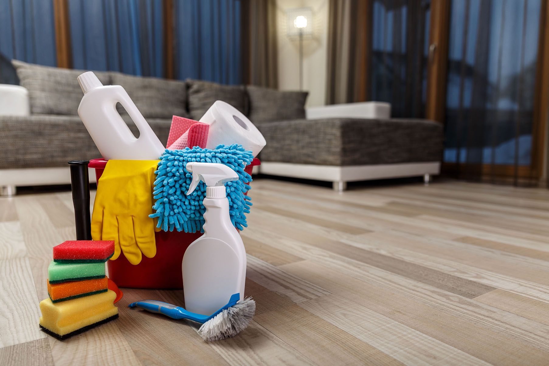 Cleaning supplies are sitting on the floor in a living room.