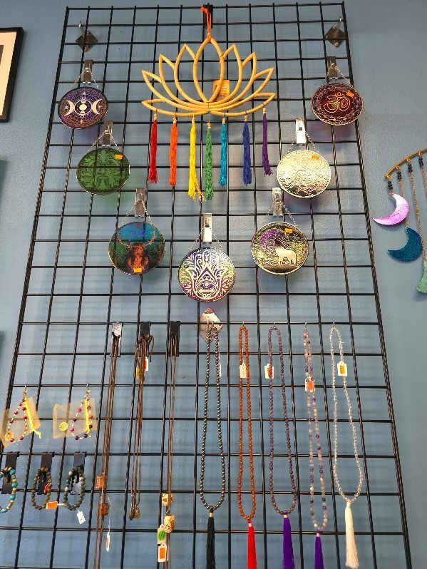 A bunch of necklaces are hanging on a wire rack