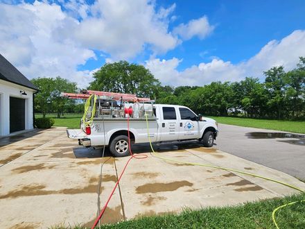 A white truck is parked in a driveway next to a house