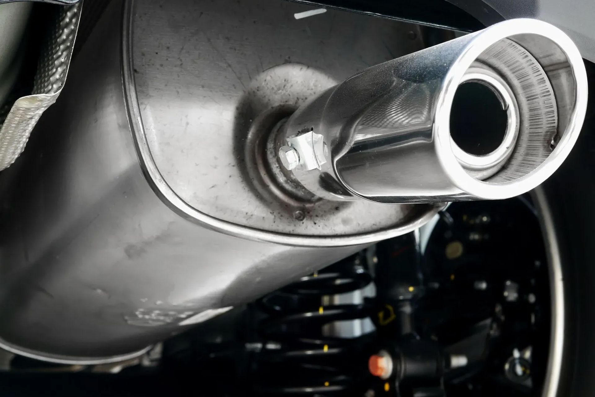 Car exhaust pipe, silver metal, mounted under vehicle, angled view.