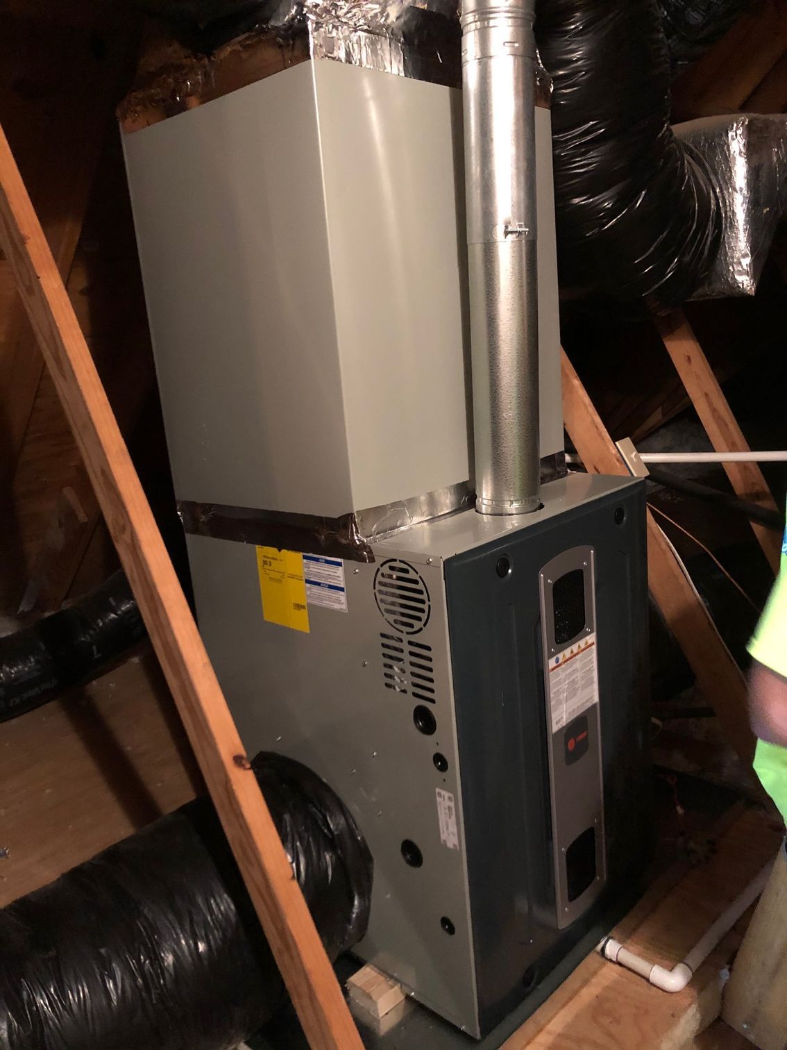 a person is standing next to a heater in an attic