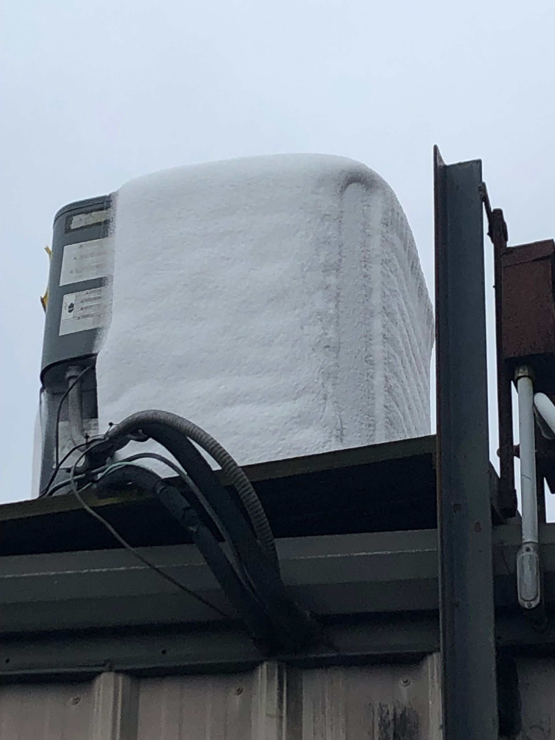 a large container covered in snow is sitting on top of a building
