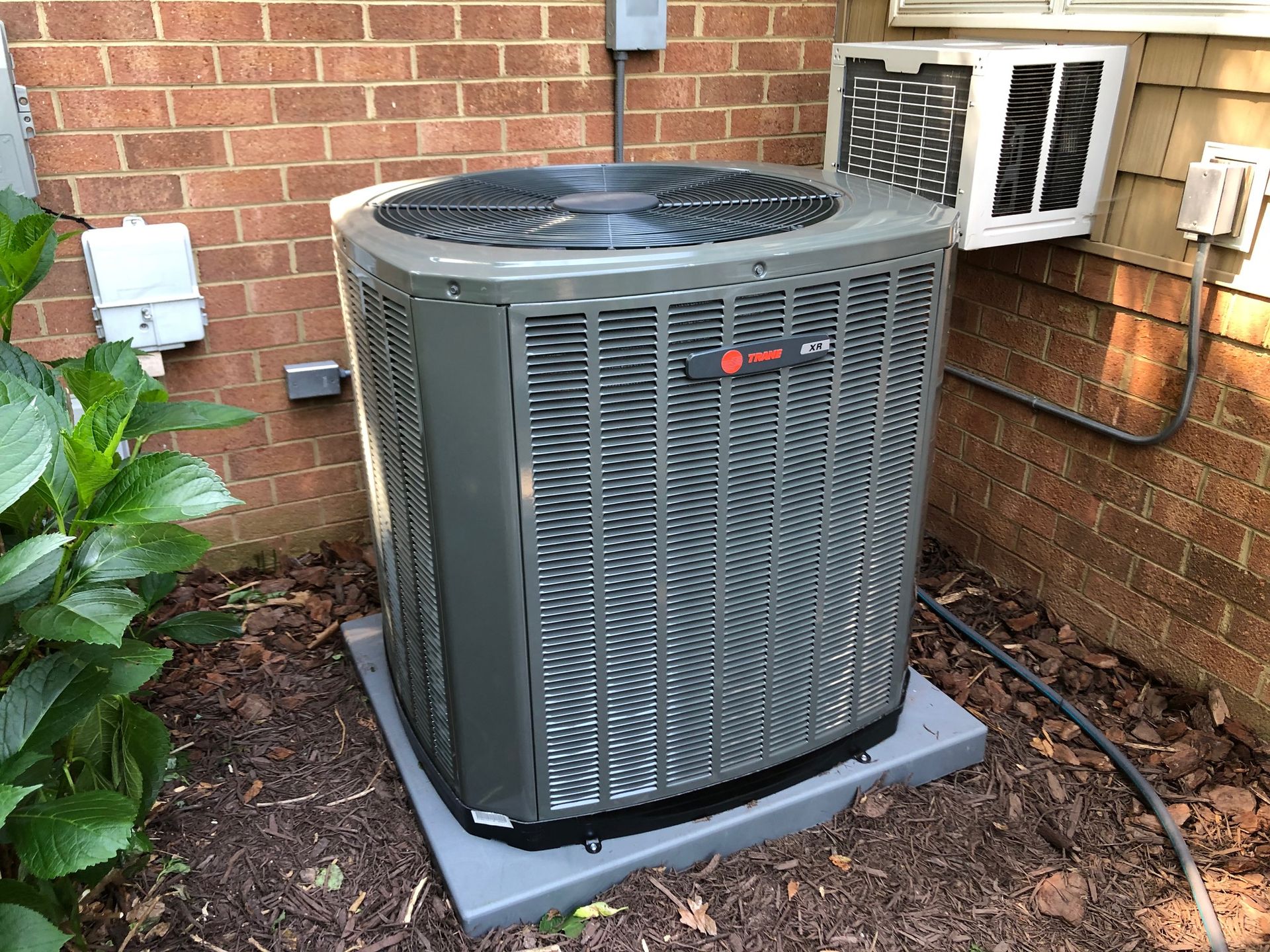 a large air conditioner is sitting outside of a brick building