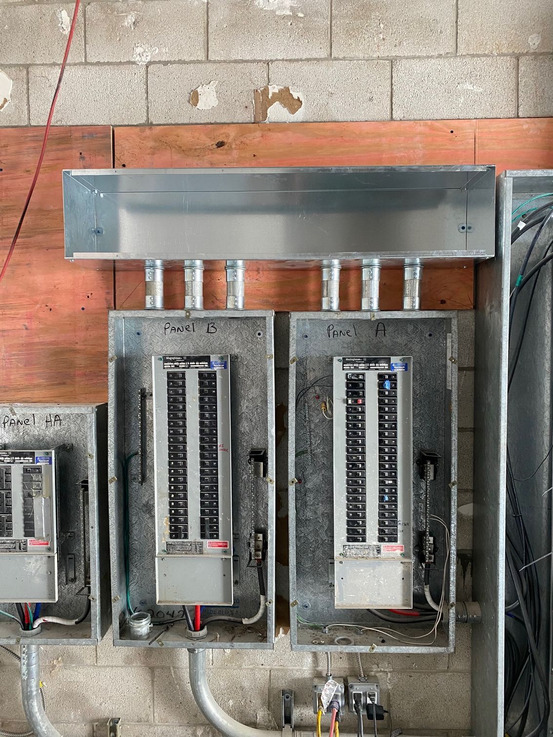 a bunch of electrical boxes are hanging on a brick wall