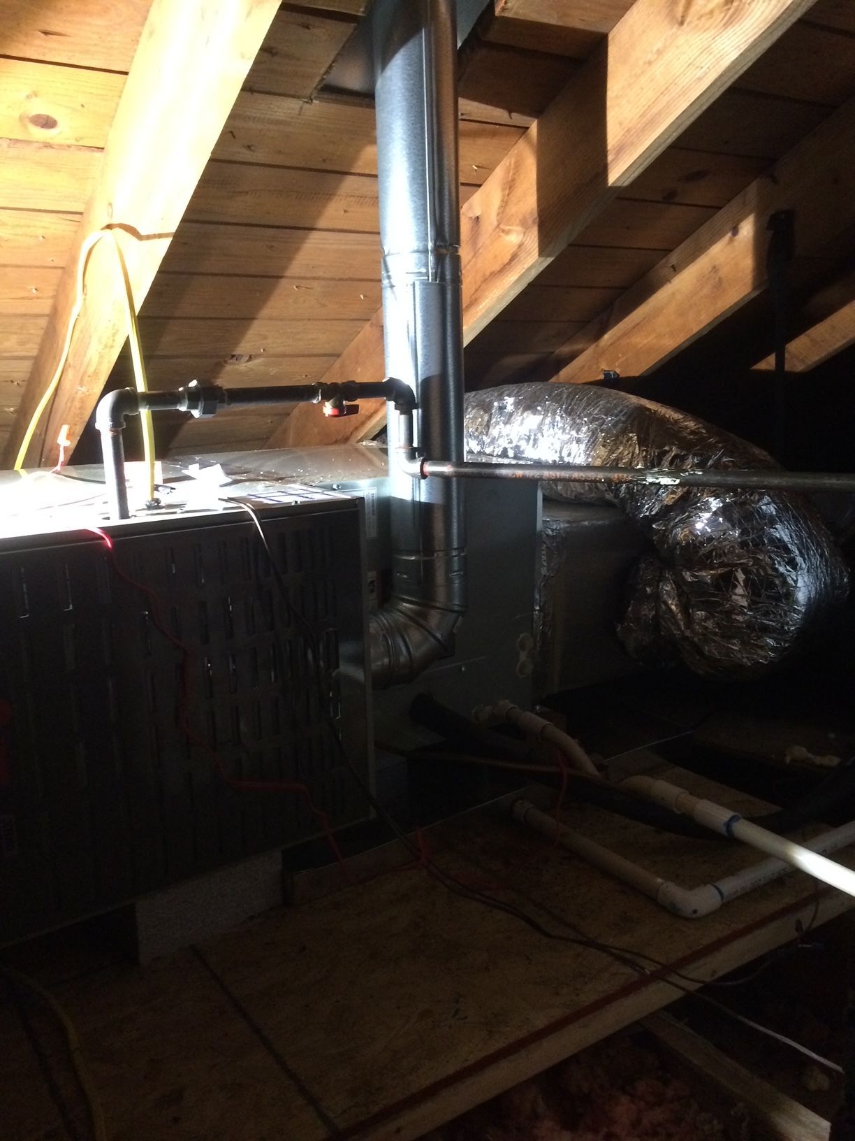 a pipe is hanging from the ceiling of an attic 
