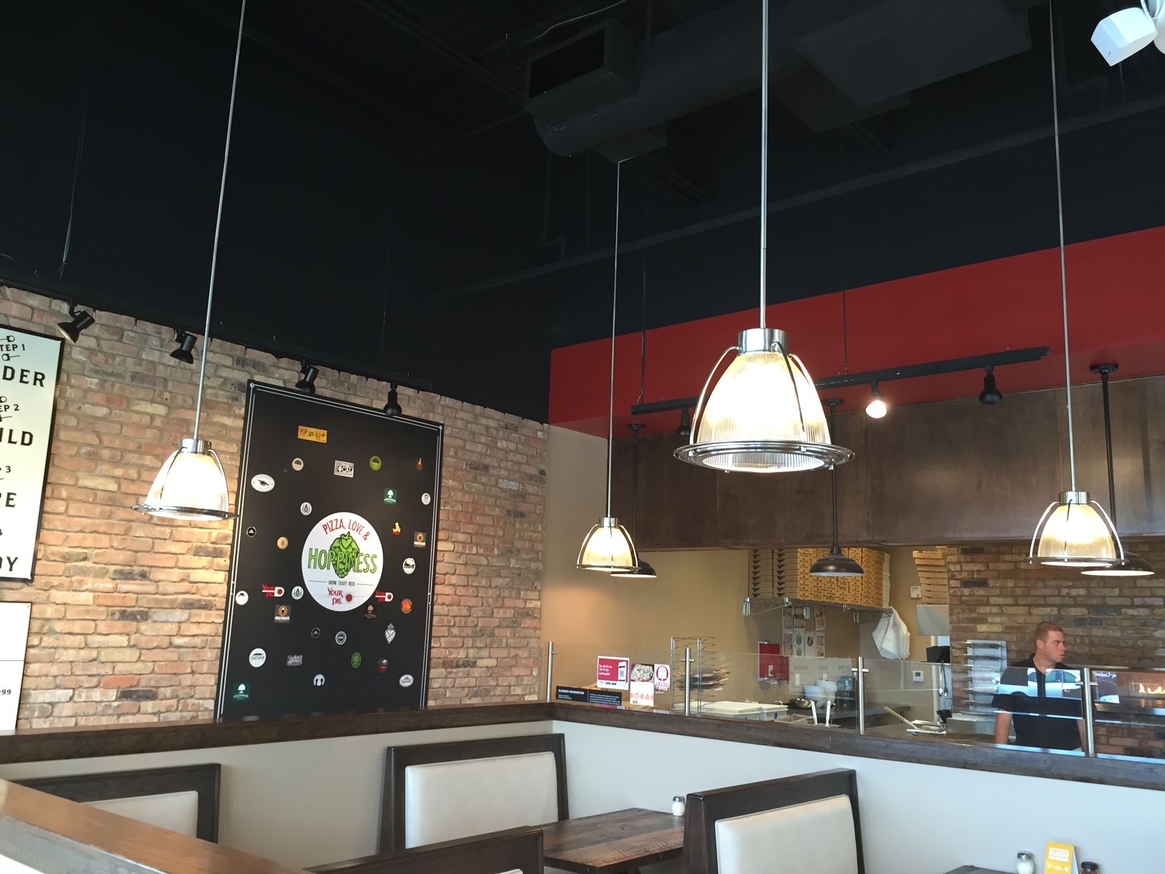the inside of a restaurant with a brick wall and tables and chairs