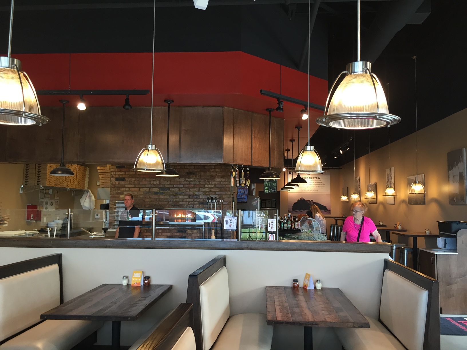the inside of a restaurant with tables and benches