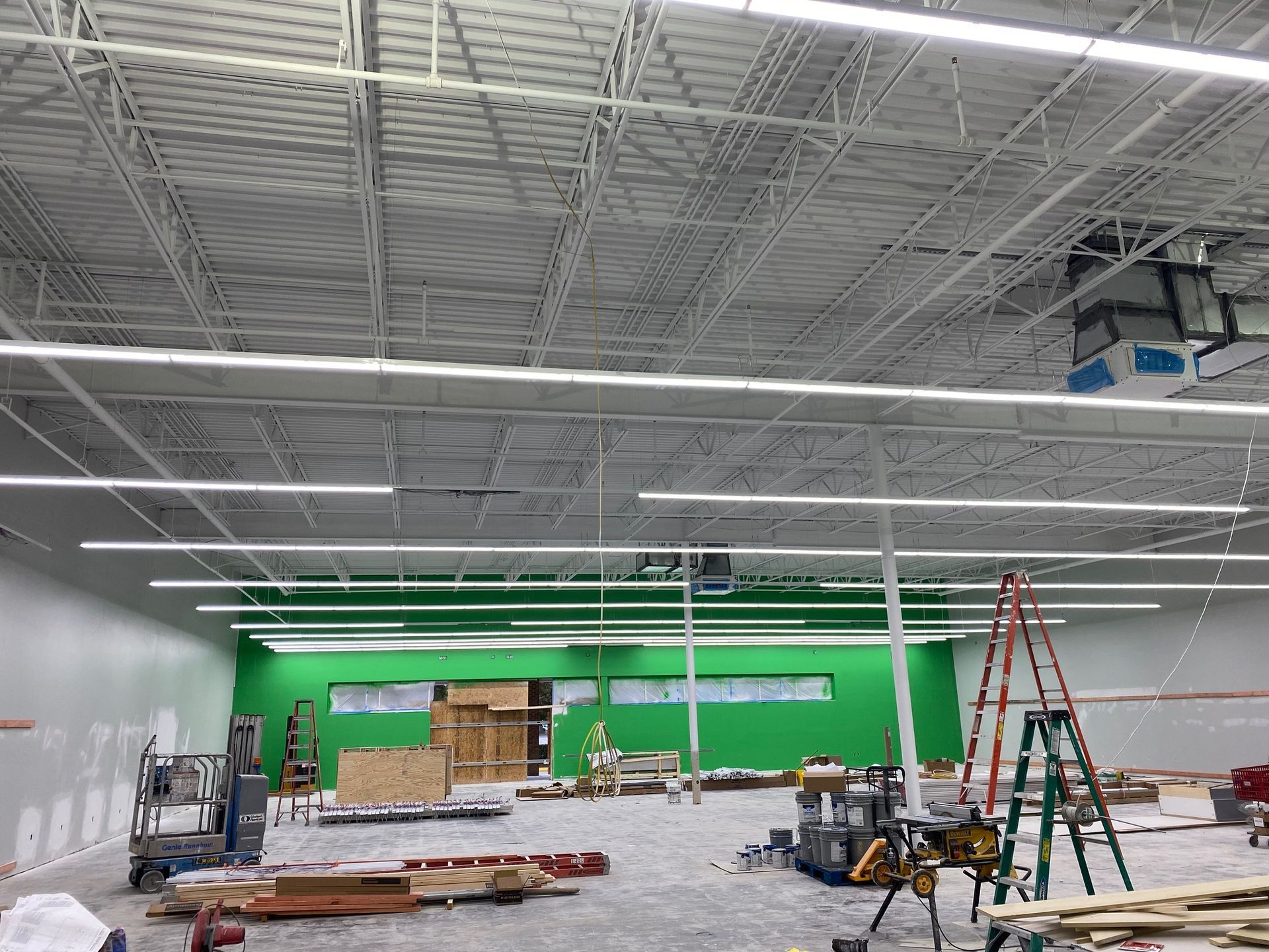 the inside of a building under construction with a green wall