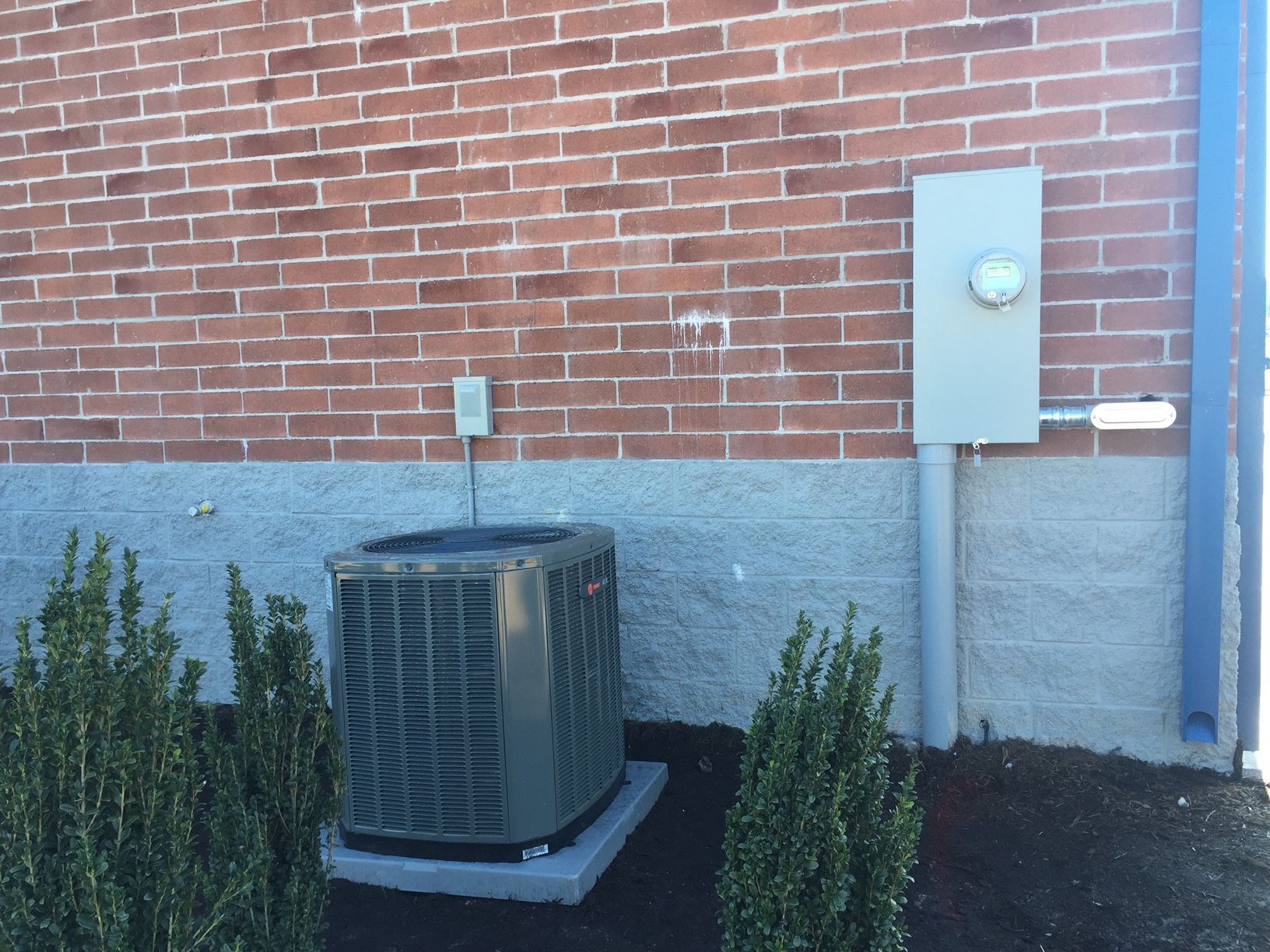 an air conditioner is sitting on the side of a brick building 